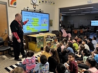 person teaching about scientific method in front of a Cleverboard
