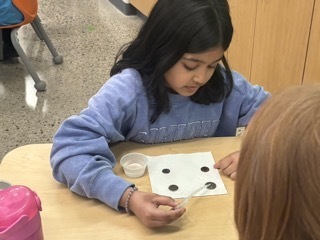 child putting water droplets on change