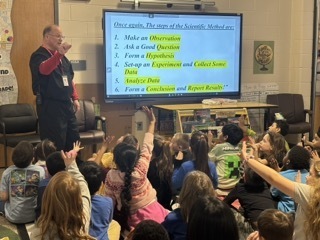 person teaching about scientific method in front of a Cleverboard