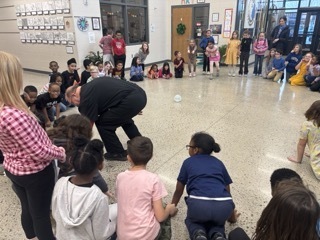 person rolling 2 hamsters around in hamster balls with students