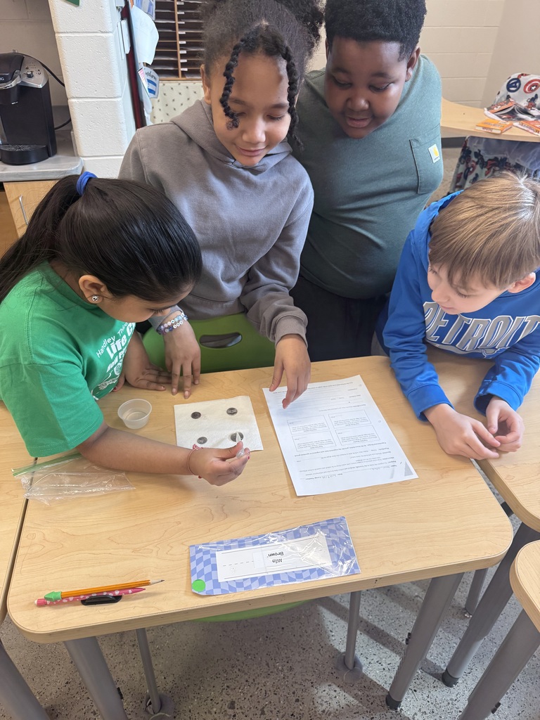 child putting water droplets on coins with eyedropper