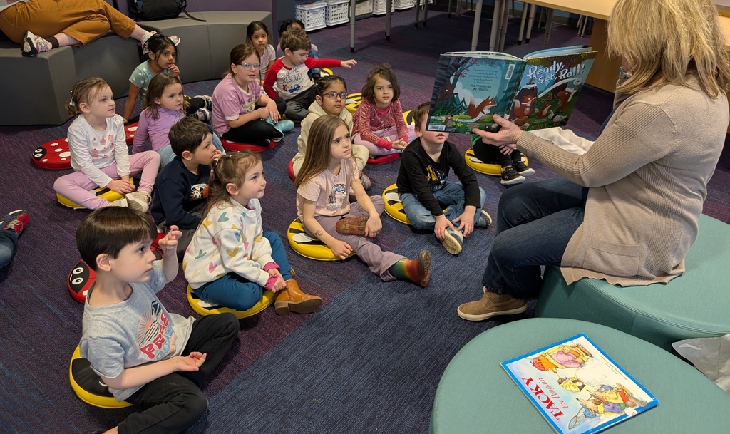 Librarian reading to students the book is "ready set roll"