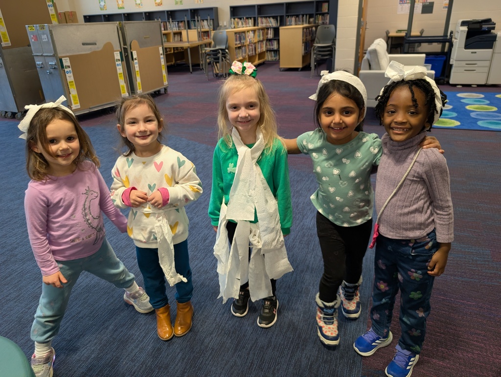 5 children standing together wearing various forms of toilet paper fashion
