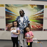 2 children standing with adult. holding certificate. 
