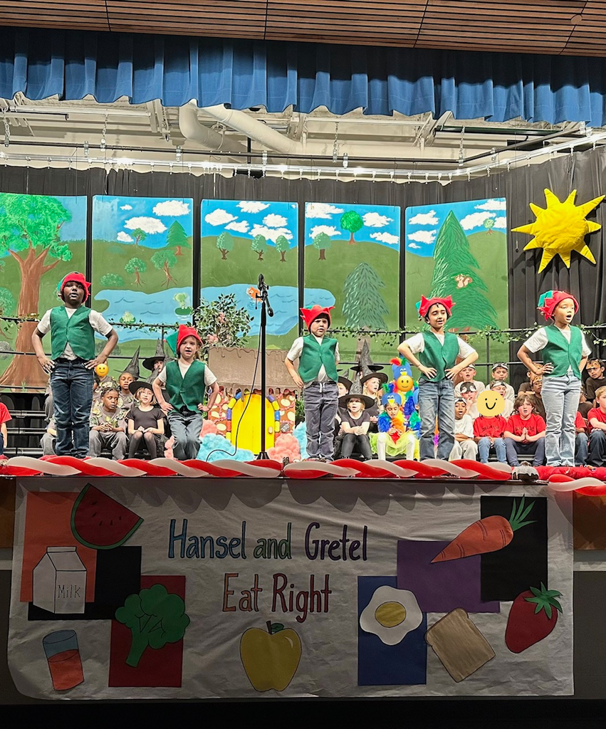 students on stage front 5 dressed as elves