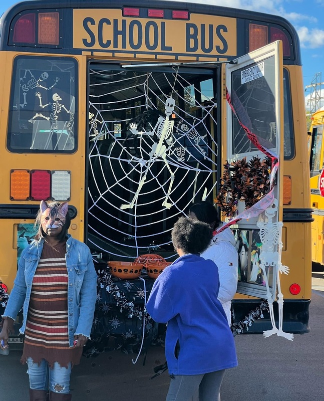 Students look at a Halloween decorated school bus