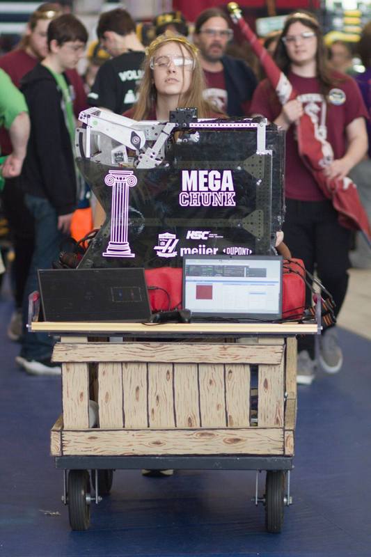 student poses with competition robot Mega Chunk