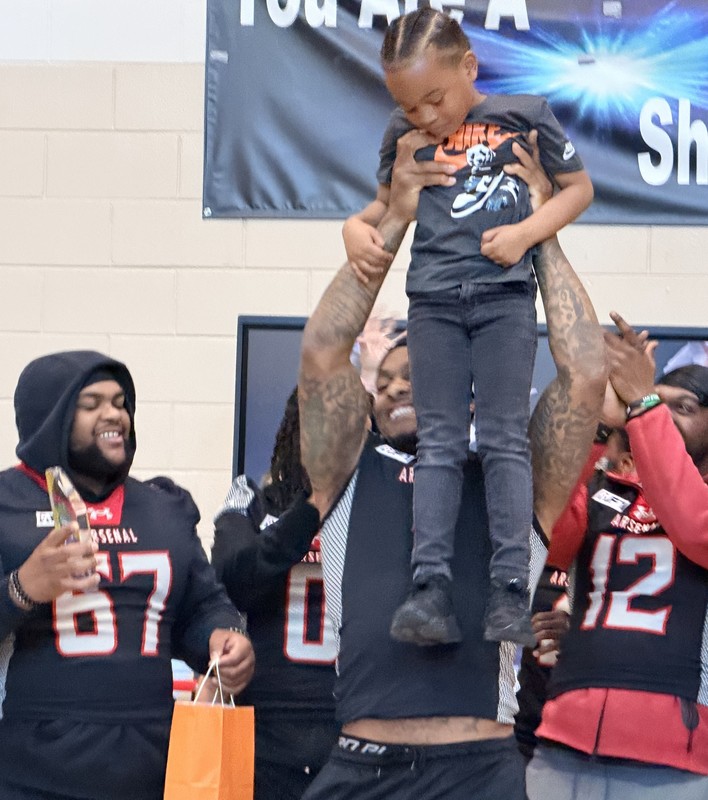 Michigan Arsenal football players celebrate student's acheivement during assembly