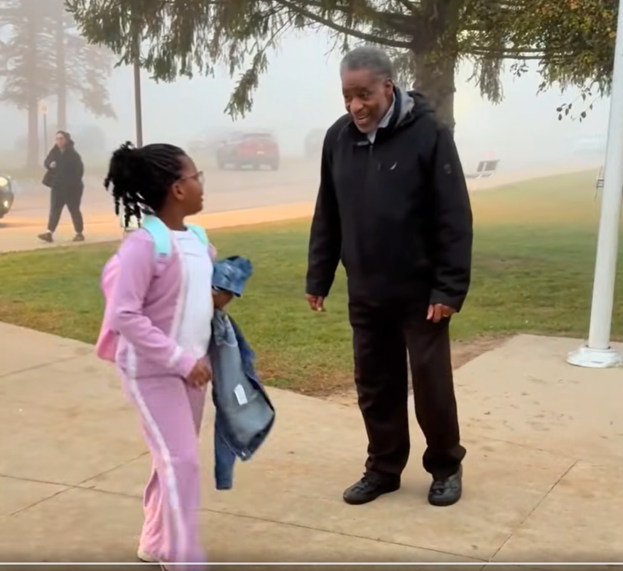 man greeting child at school