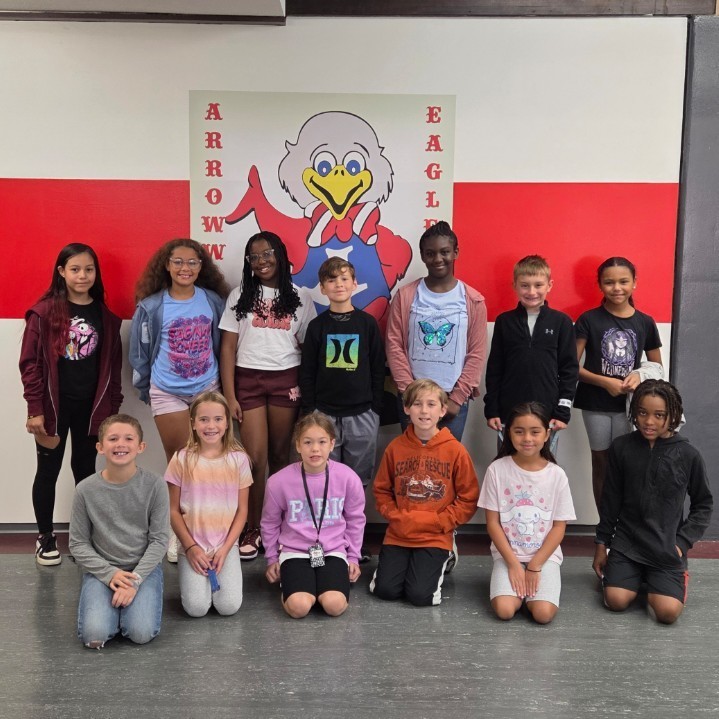 students pose in two rows and smile