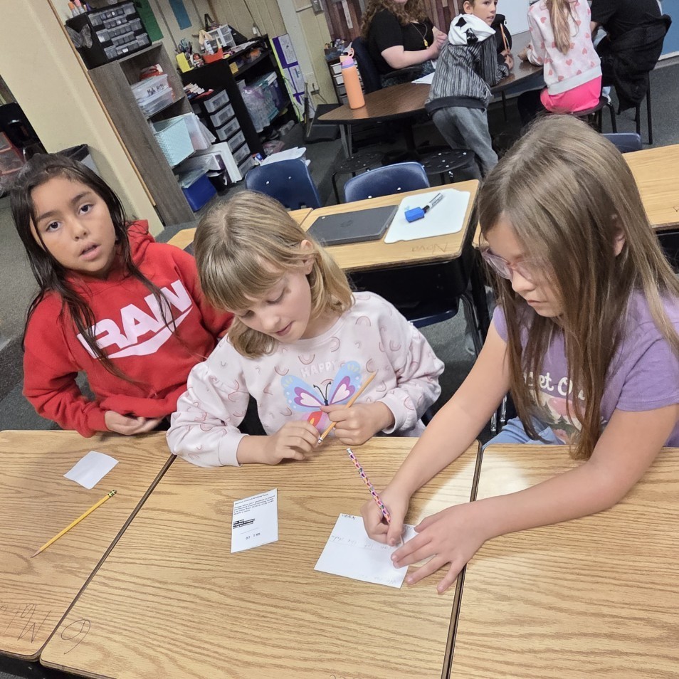 3 girls work on task card