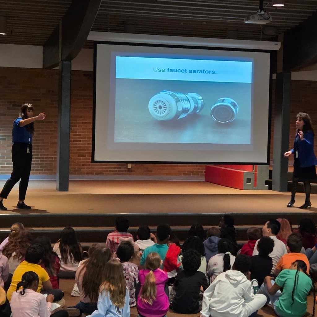 presenters explain faucet aerator to students
