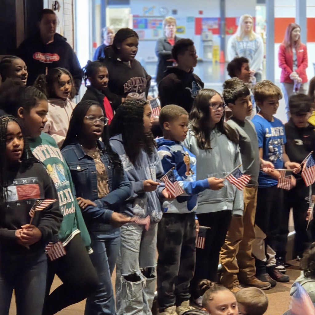 students stand and sing with flags