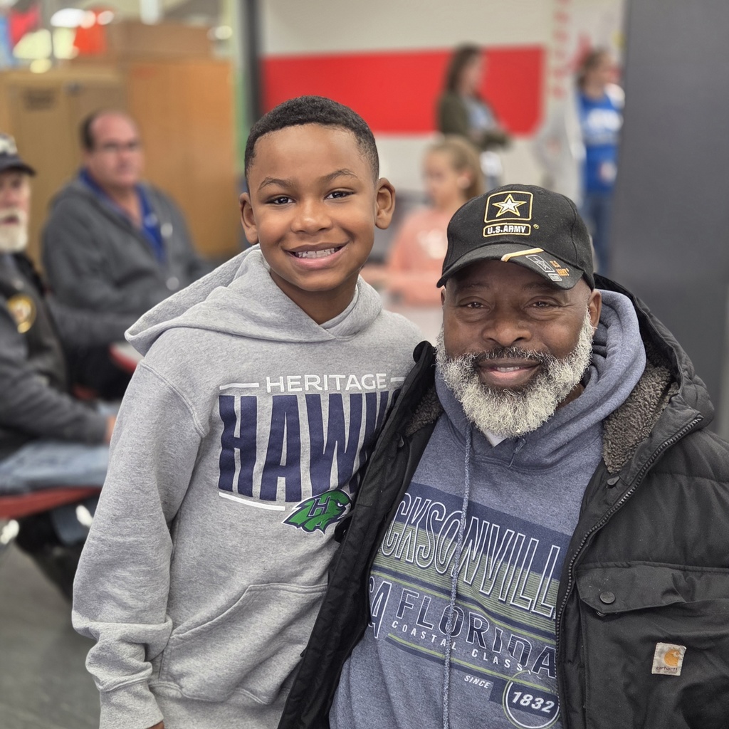 student and veteran smile together