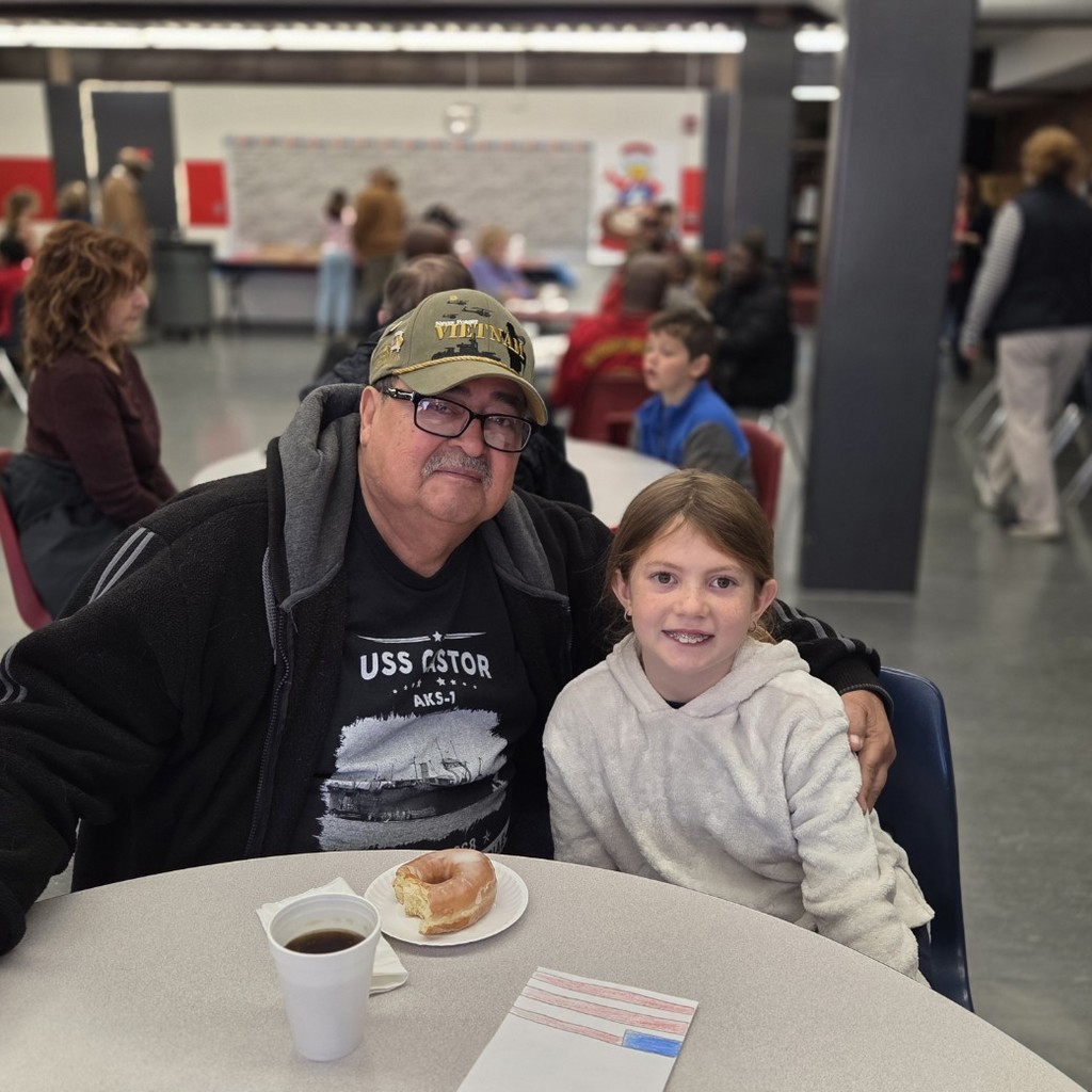 student smiles with Vietnam veteran