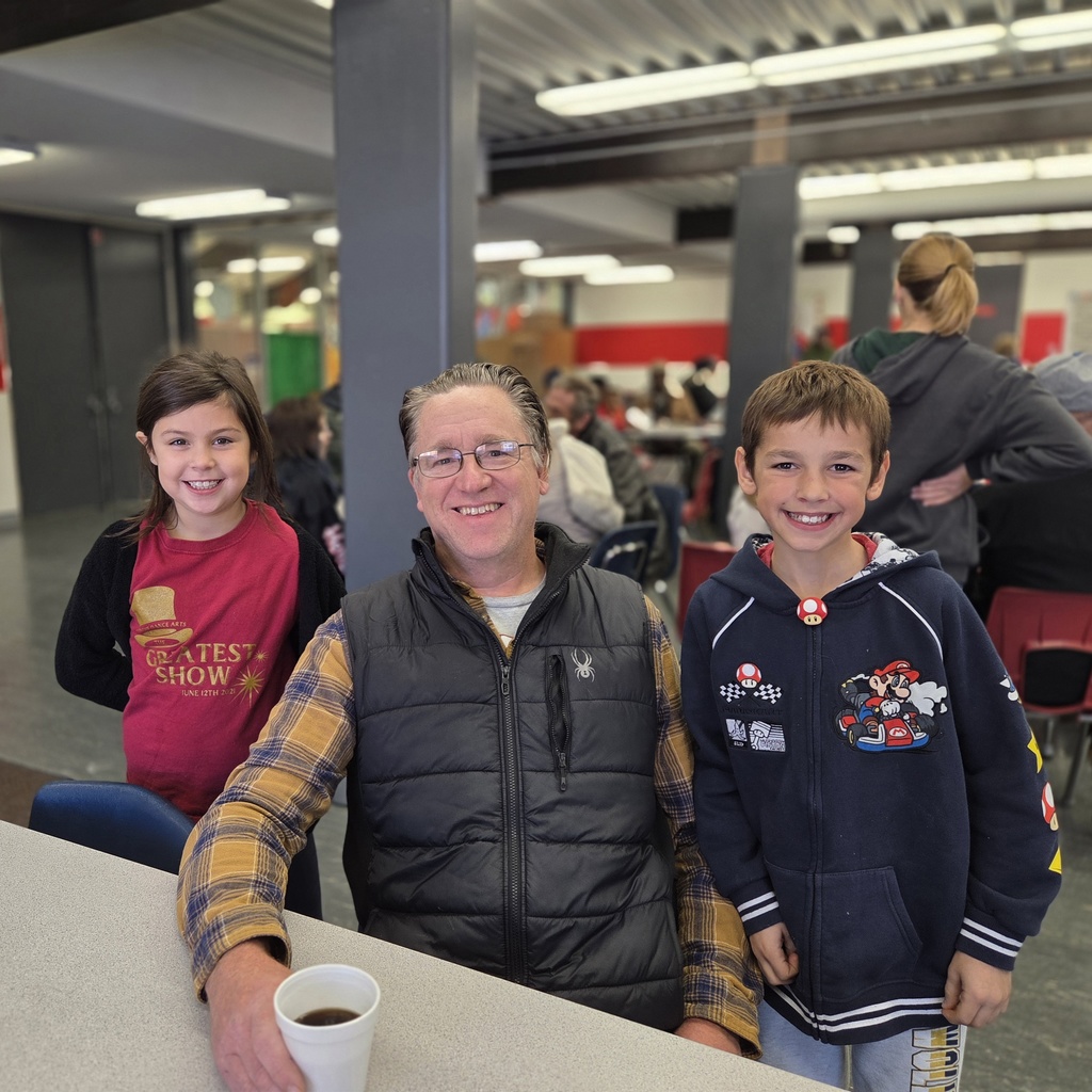 brother and sister smile with grandpa