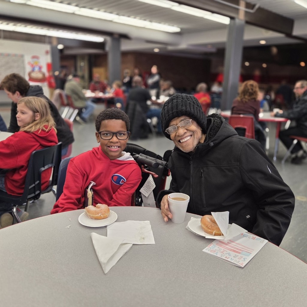 student and veteran smile with Donuts and coffee
