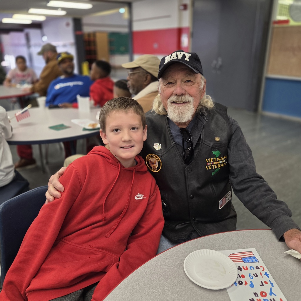 student smiles with his Navy veteran guest