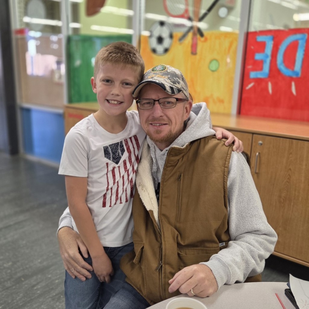 student smiles with his dad, a veteran