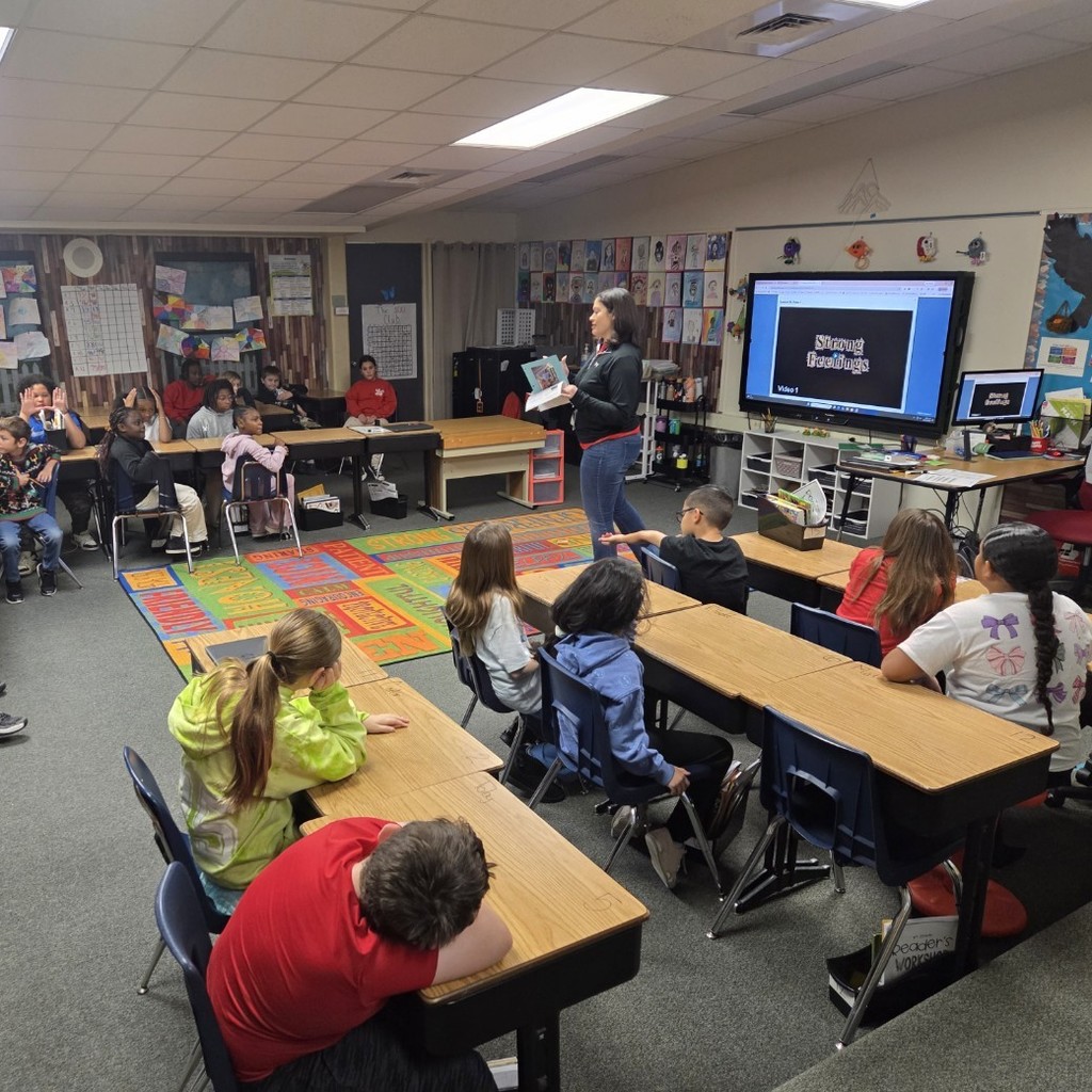 social worker in front of students at desks, strong feelings video on screen