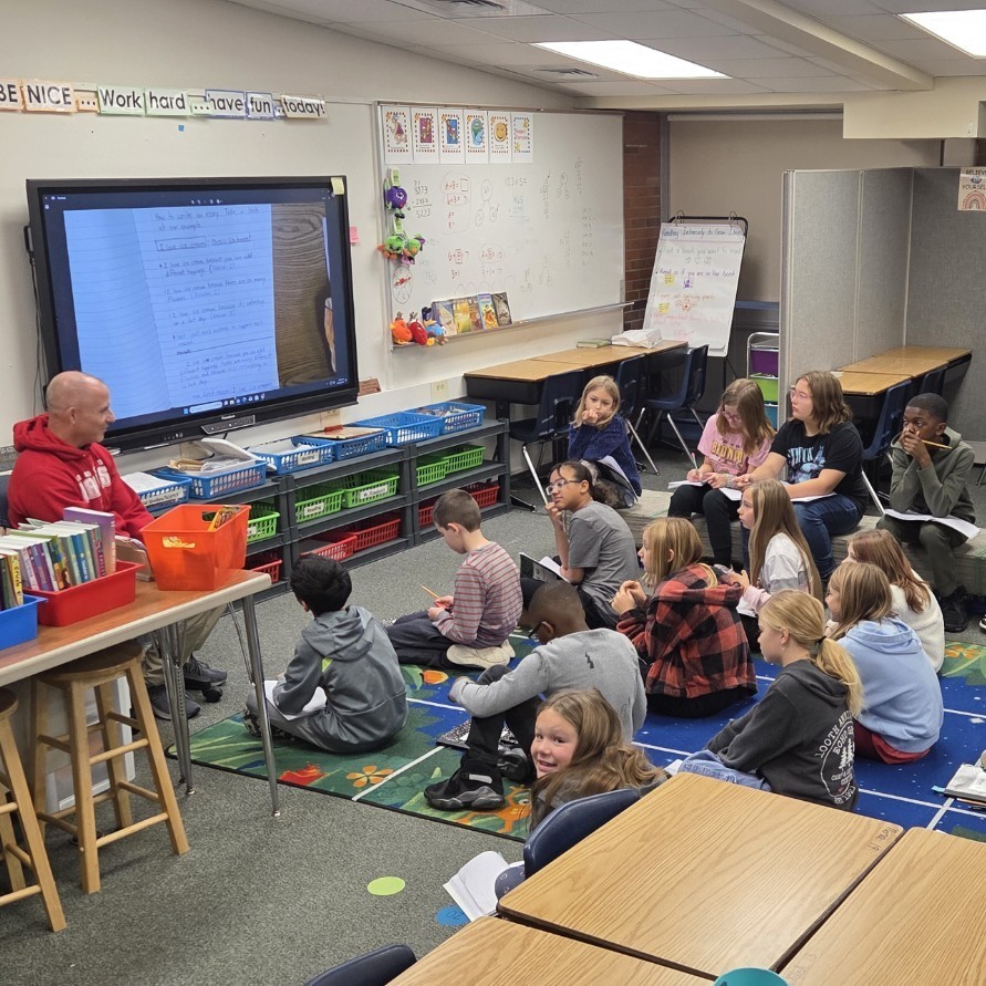 teacher with students gathered at carpet