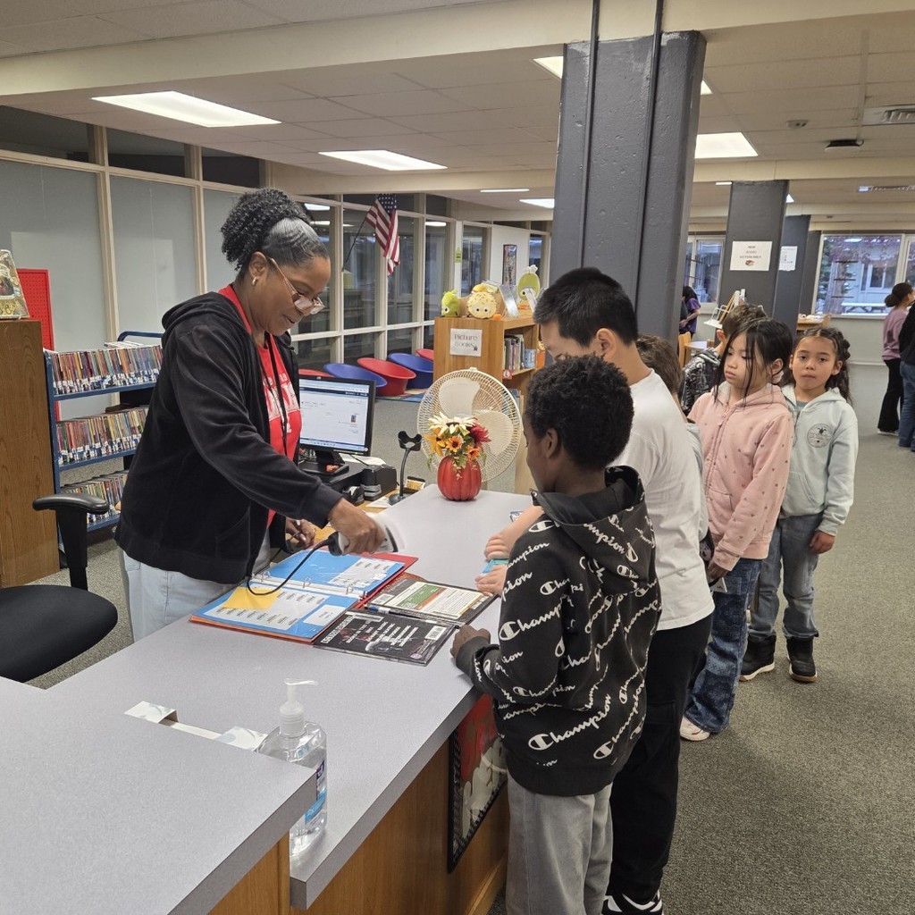 students check out books in the library