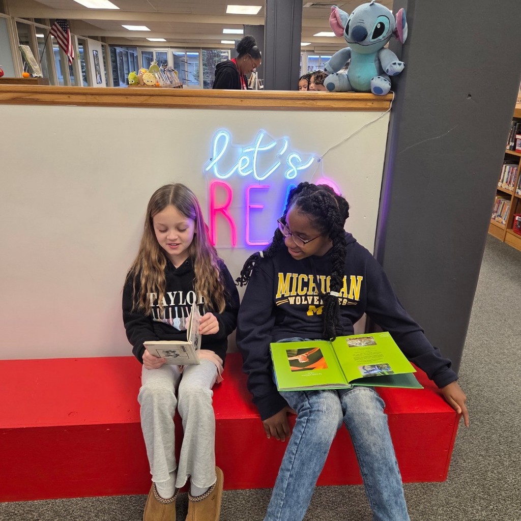 girls read together in school library