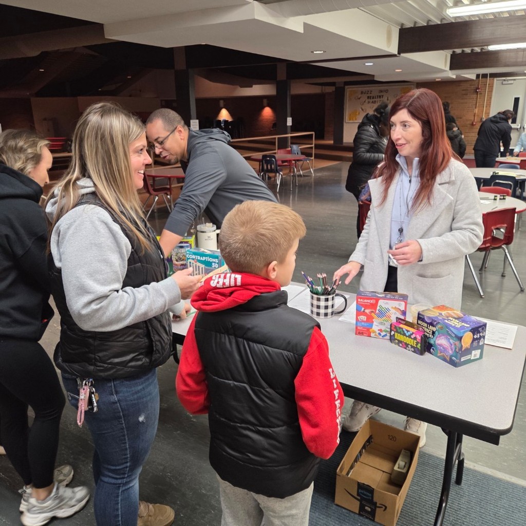 staff welcome families to STEAM night