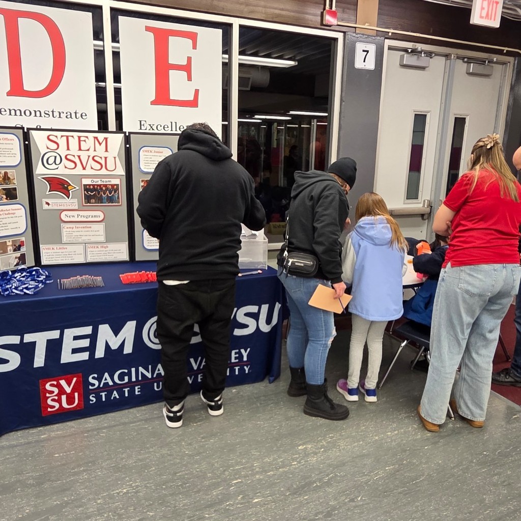 families gather around table with info and activity