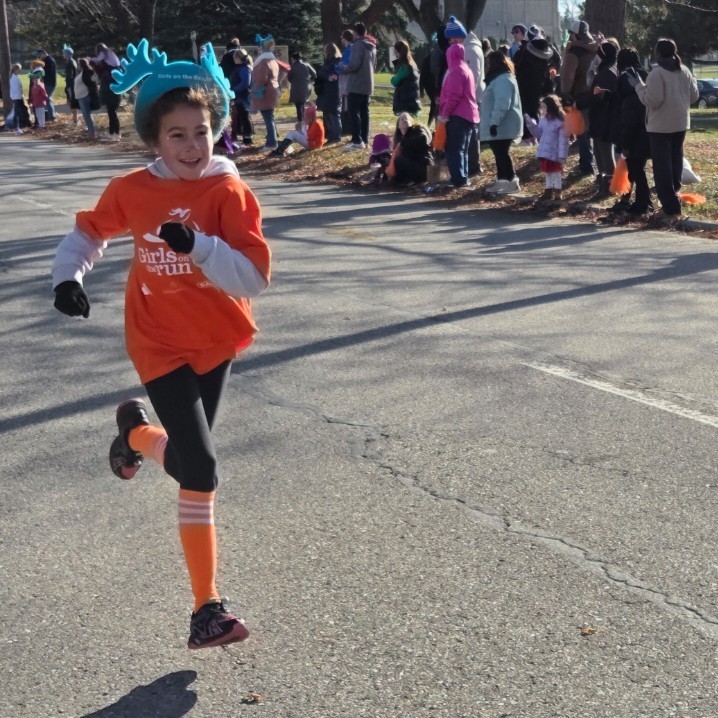student runs towards finish line