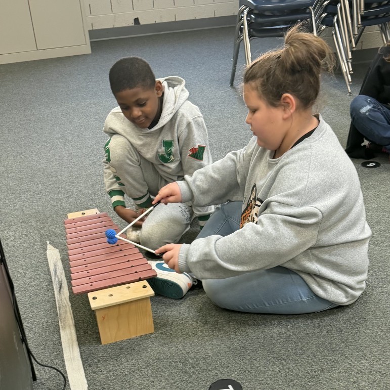 students play instrument together