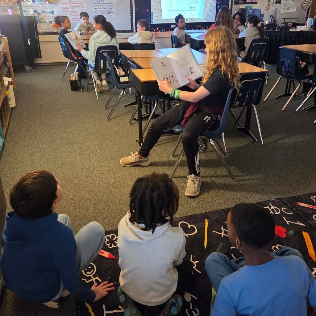 student reads to 3 boys