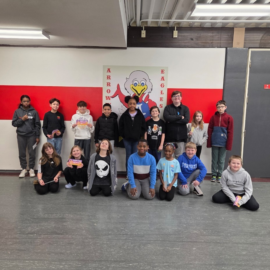 students pose in front of mascot