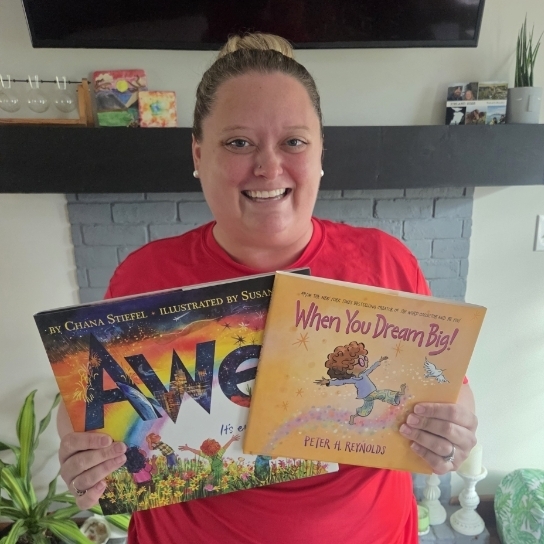 Assistant principal smiles holding 2 books
