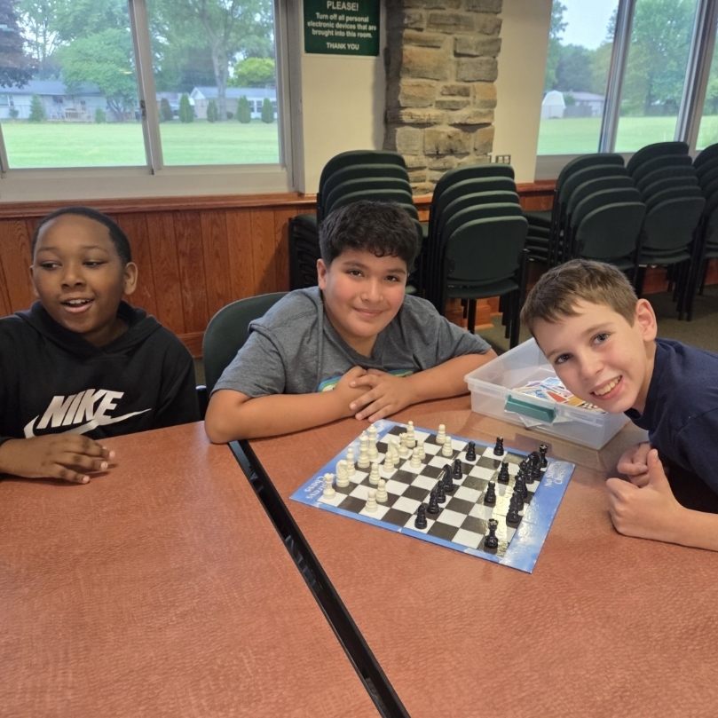 3 boys play chess