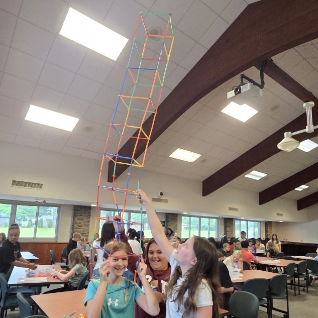 3 girls with tall tower worn as hat