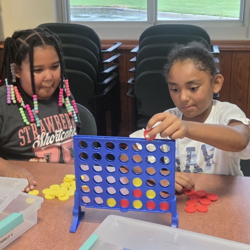 2 girls play connect 4