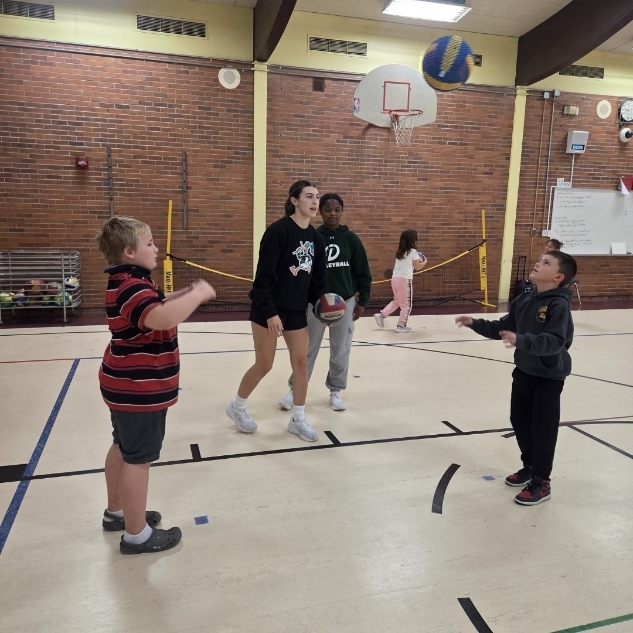 players coach students in gym class