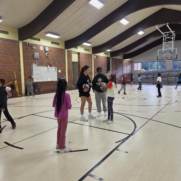 players help student in gym class