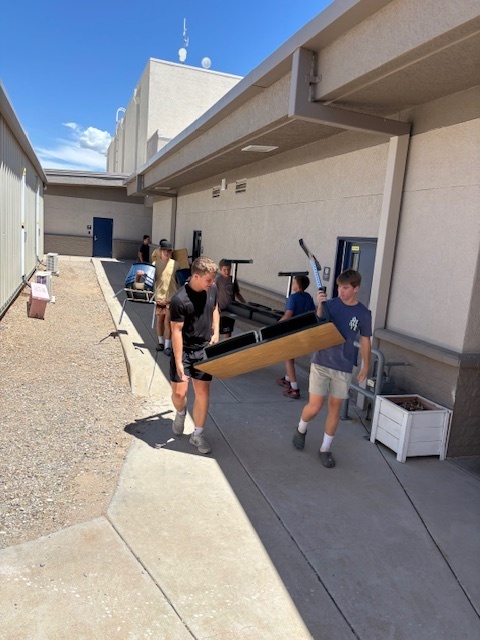 boys carrying out tables