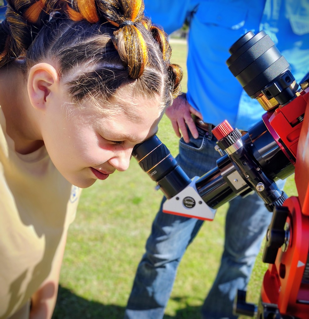 student looking in telescope