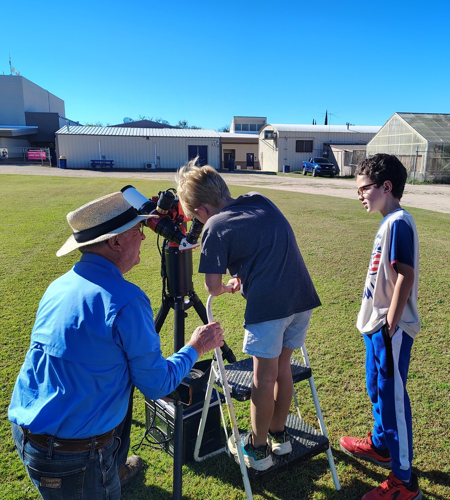 student looking in telescope