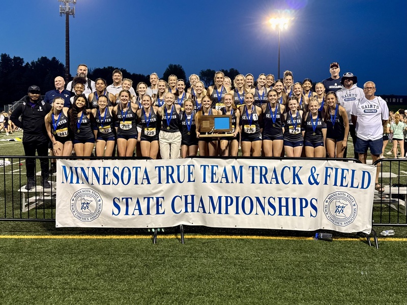 The Saints' girls track team receiving the True Team State AA championship trophy.