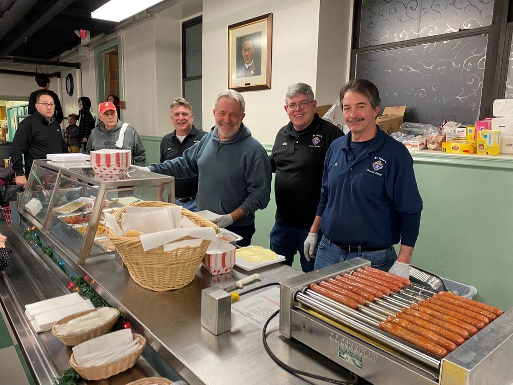 A group of men serving food at the Christmas Bazaar