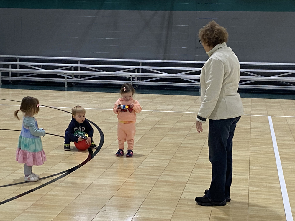 A group of students with an adult woman in the St. Peter School Gym