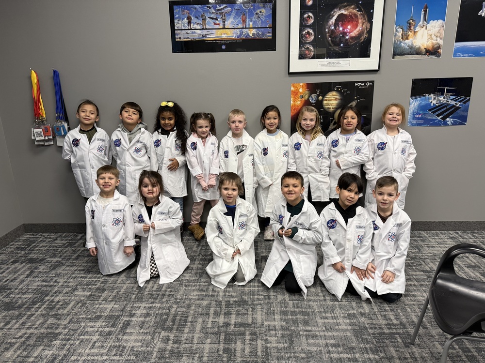 Students dressed in white coats on a Field trip to the Challenger Center