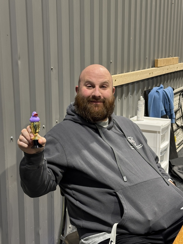 This is a picture of Coach Woody holding up his trophy for winning second place in the Ducks and Doughnuts game .