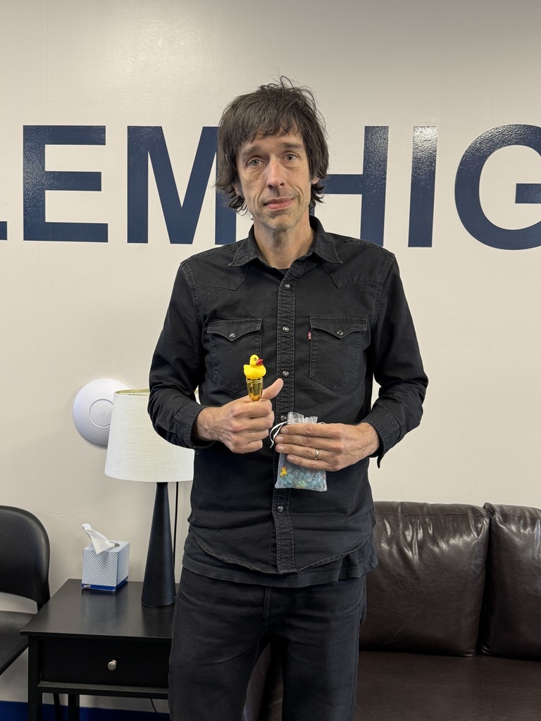 This is a picture of Mr. Wofford holding up his first place trophy for attaining 22 ducks from his co-workers during the Ducks and Doughnuts game.