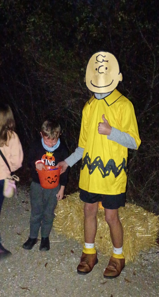 Student dressed as Charlie Brown handing out candy