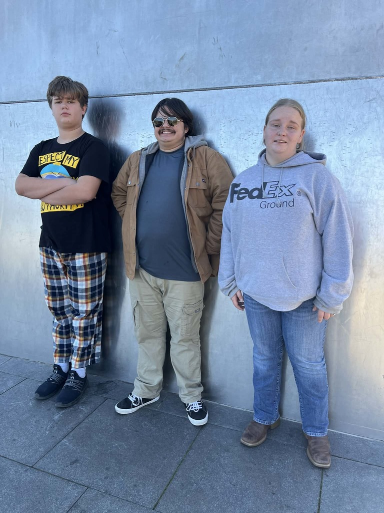 This is a picture of the students standing next to one leg of the arch.